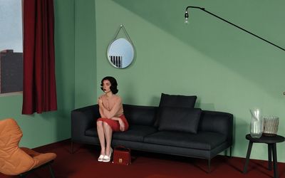 a woman sitting on a couch in a green room