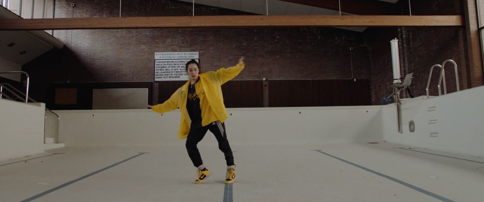 a woman in a yellow jacket is dancing