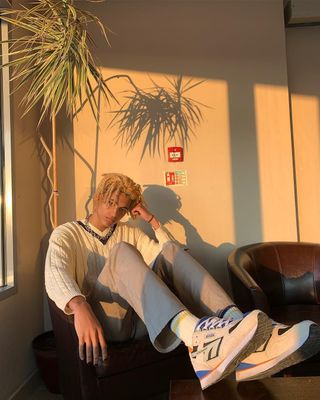 a man sitting in a chair next to a plant