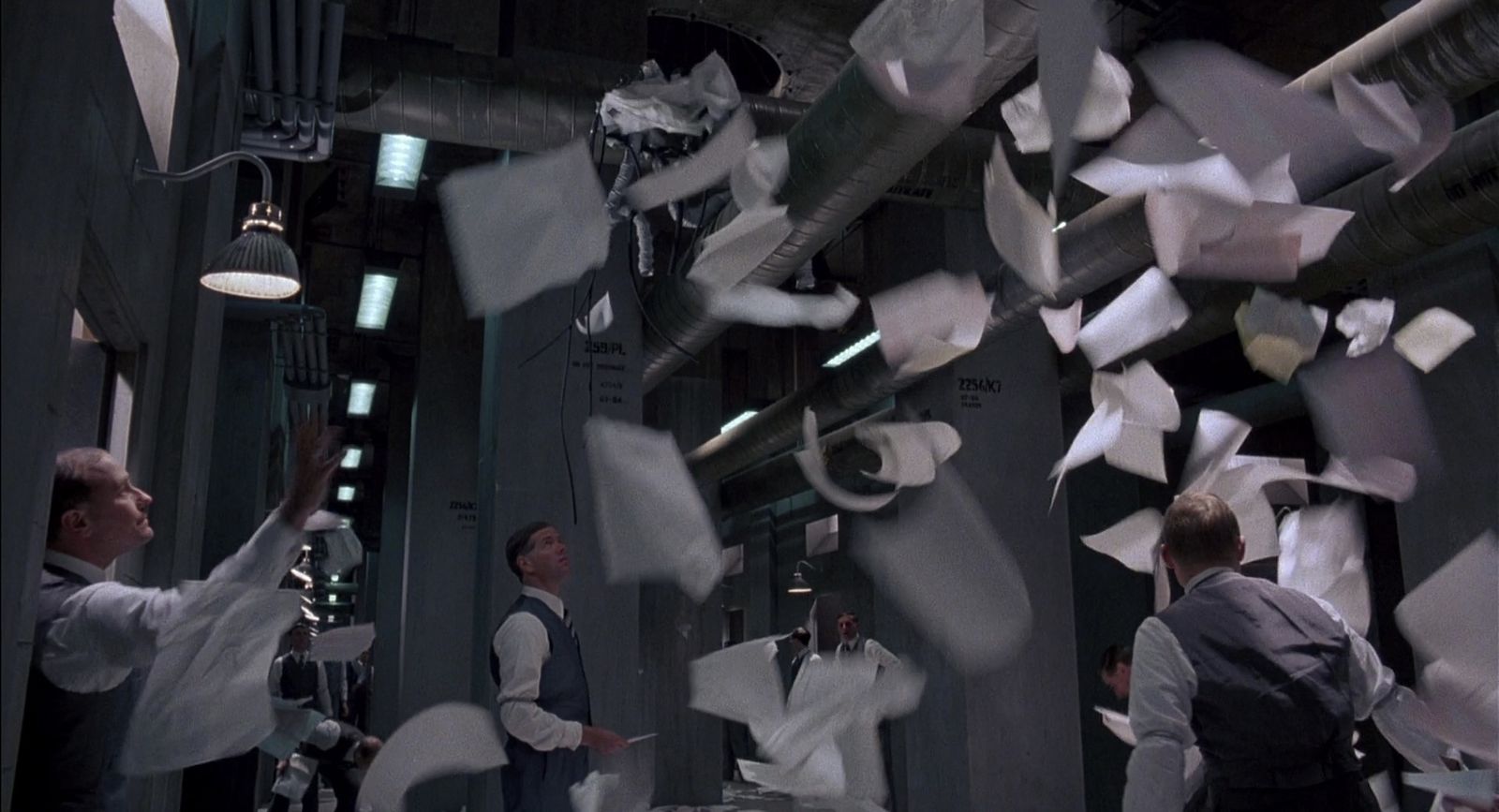 a group of men standing around a room filled with papers