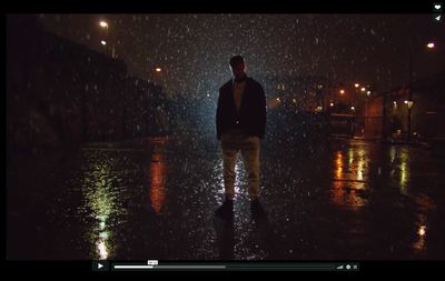 a man walking in the rain at night