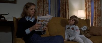 a woman sitting on top of a couch next to a child