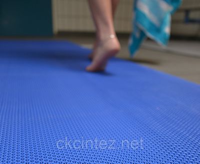 a person walking on a blue mat in a room