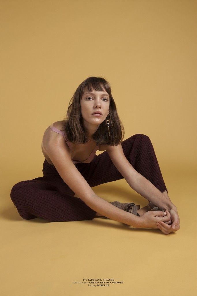 a woman sitting on the ground with her legs crossed