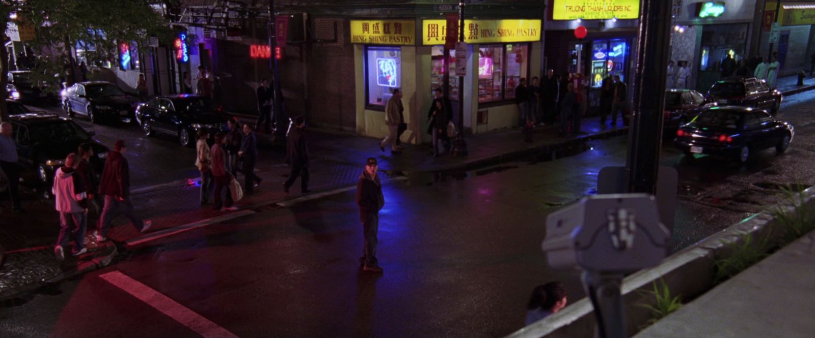 a group of people walking down a street at night