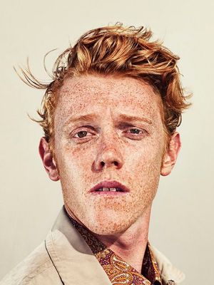 a man with freckled hair and a tie