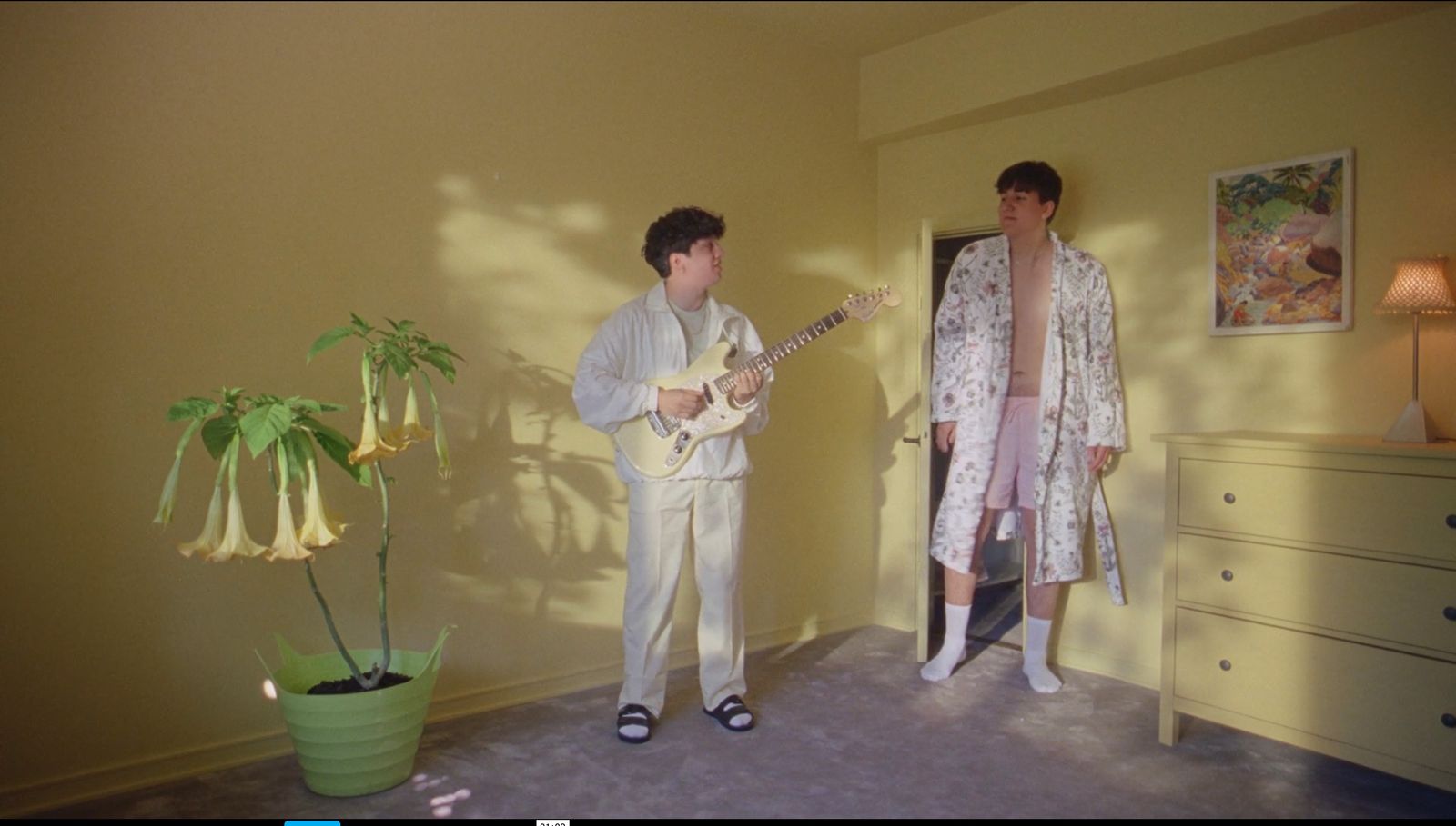 a couple of people standing in a room with a guitar