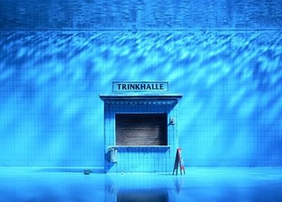 a man standing in front of a blue building