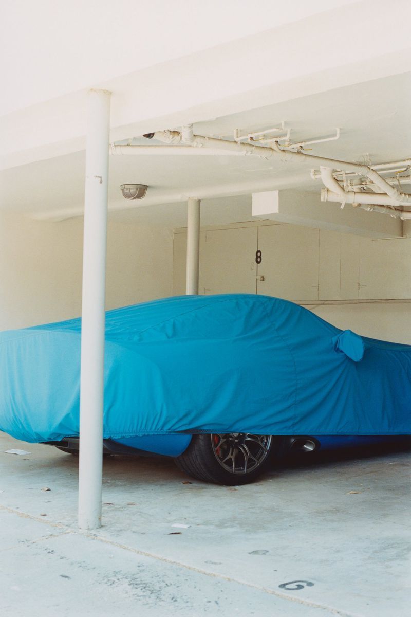 a car covered in a blue cloth in a garage