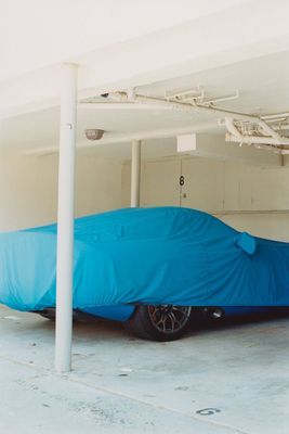 a car covered in a blue cloth in a garage