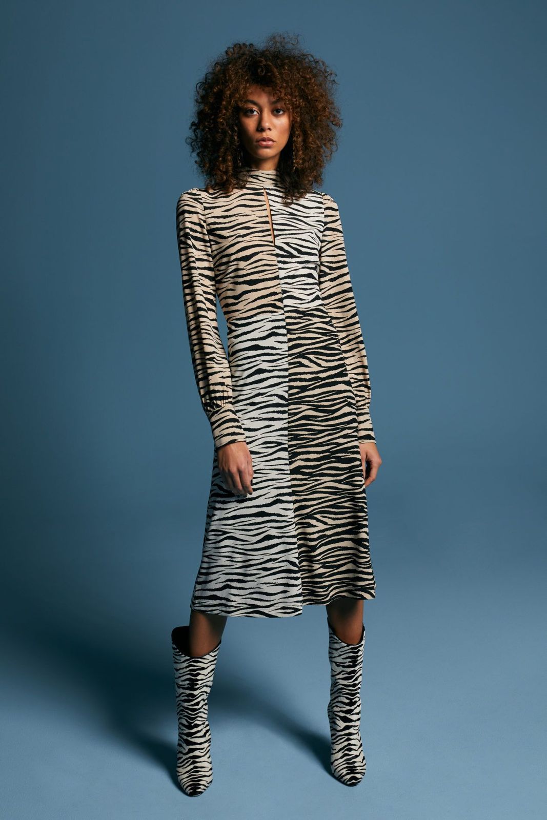 a woman in a zebra print dress and boots