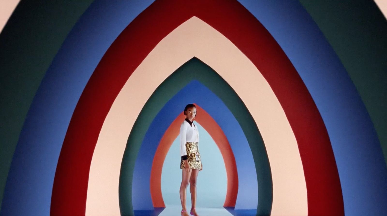 a woman standing in front of a multicolored wall