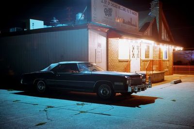 a car parked in front of a building at night