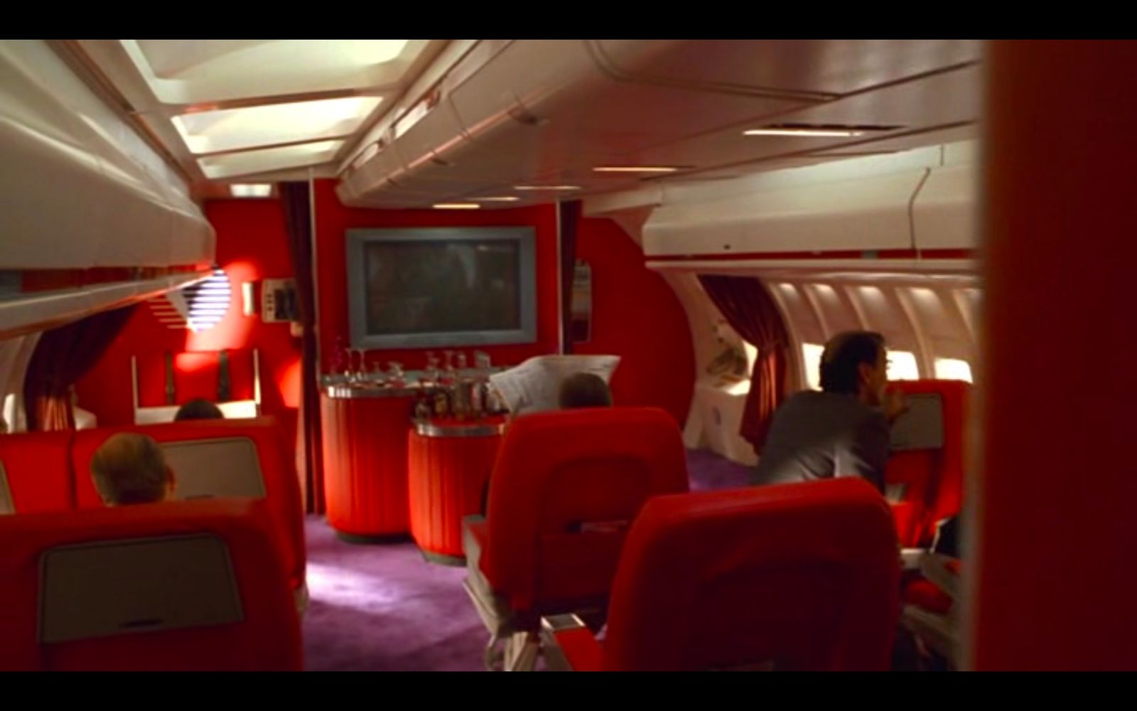 a red and white airplane with people sitting in it