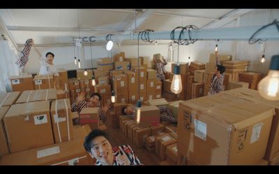 a group of people standing around a room filled with boxes