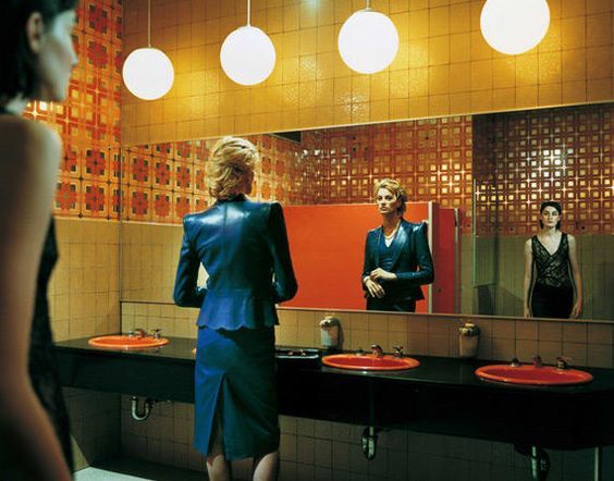 a woman standing in front of a mirror in a bathroom