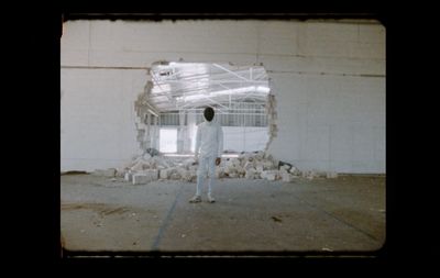 a man standing in front of a white wall