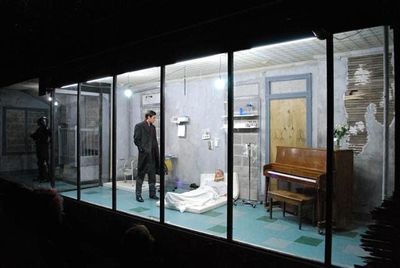 a man standing in front of a piano in a room