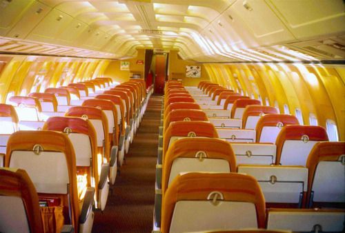 the inside of an airplane with rows of empty seats