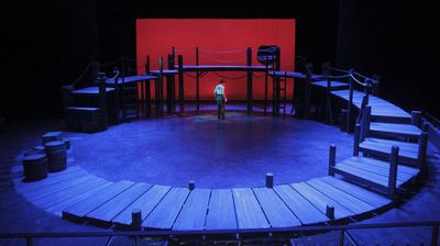 a man standing on a stage in front of a red screen