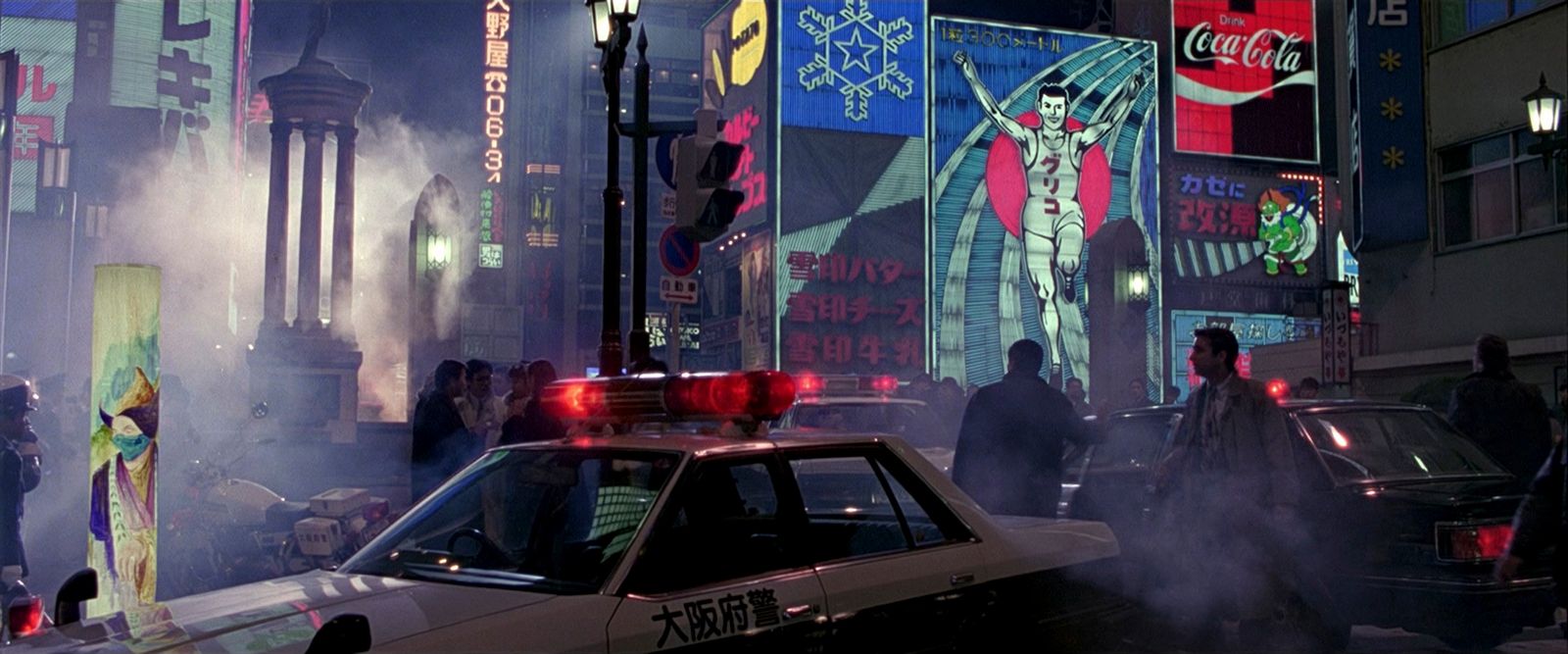 a police car driving down a street next to tall buildings