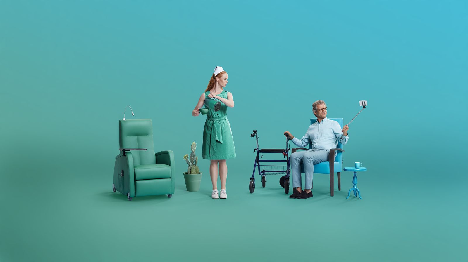 a woman in a green dress standing next to a man in a blue chair