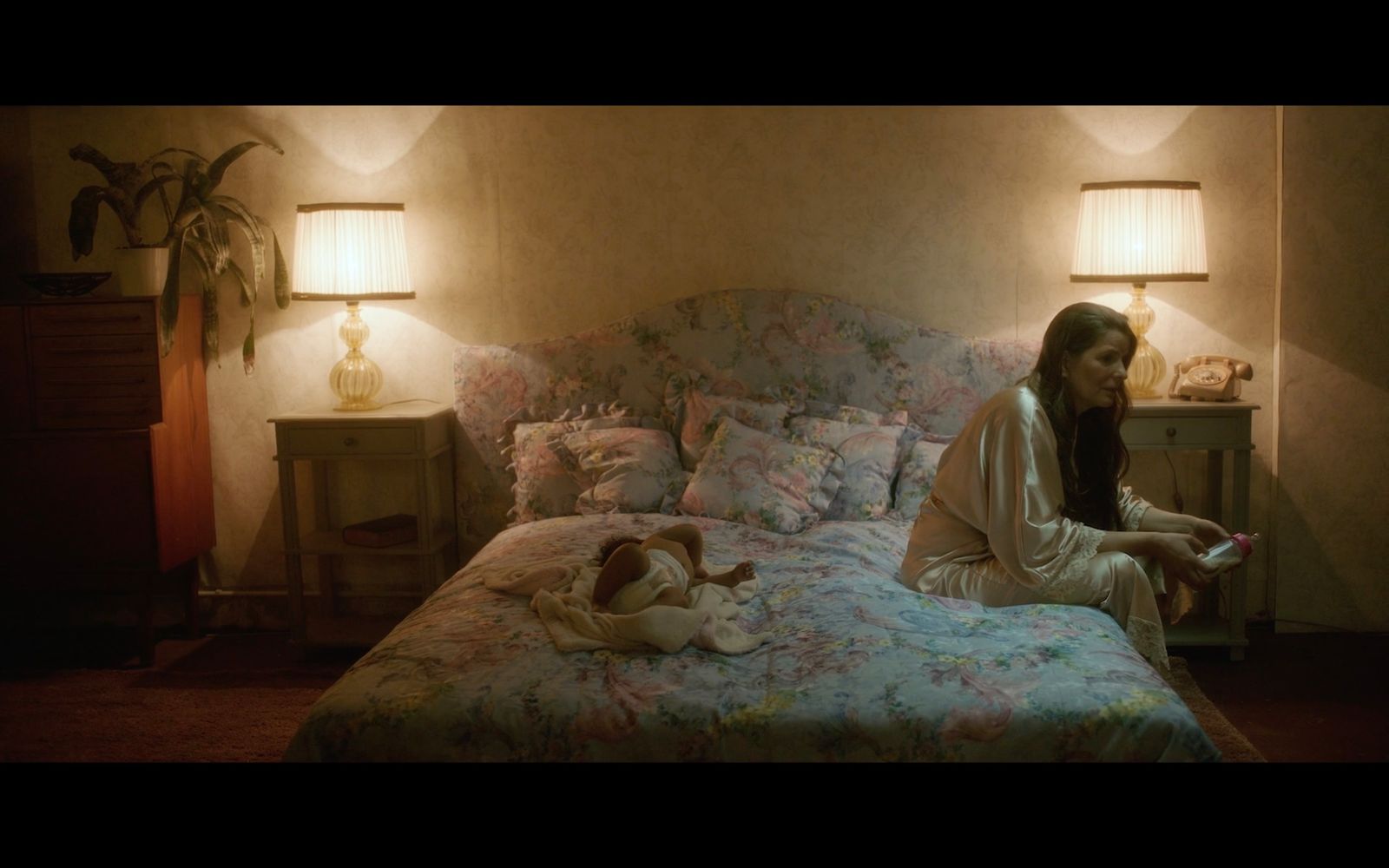 a woman sitting on a bed in a bedroom