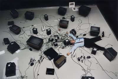 a man laying on the ground surrounded by electronic equipment