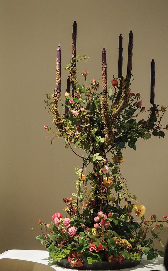 a large arrangement of flowers and candles on a table