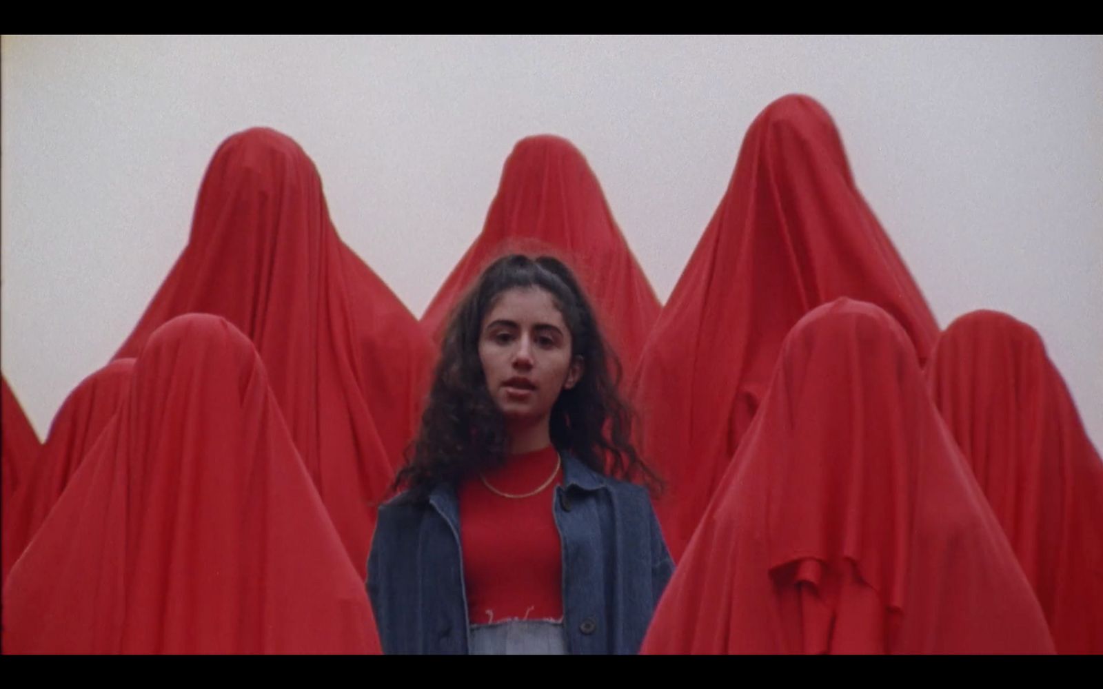 a woman standing in front of a group of red cloths