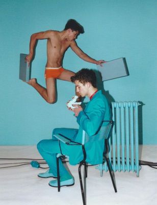 a man in a blue suit jumping over another man in a blue suit