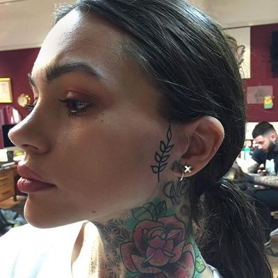 a woman with a flower tattoo on her neck