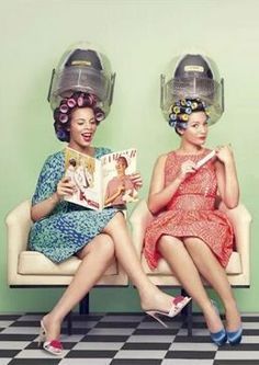 a couple of women sitting on top of a white couch