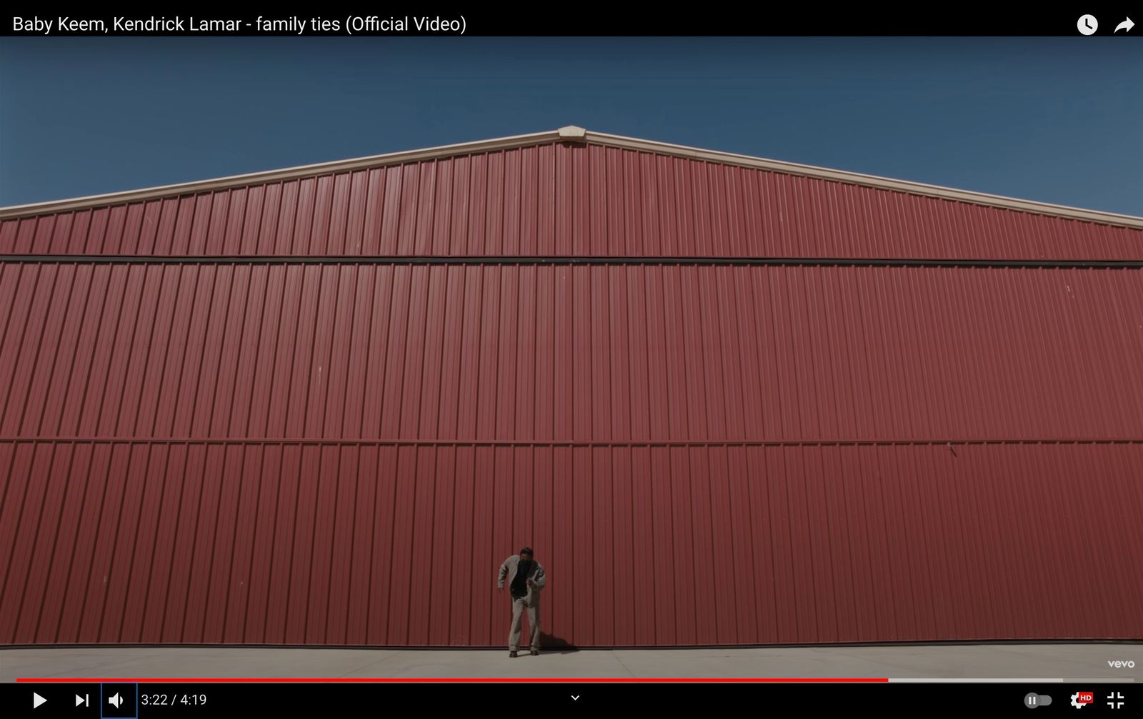 a man standing in front of a red building