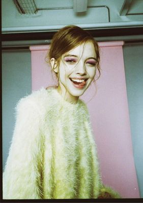 a woman with makeup on her face and a fuzzy coat