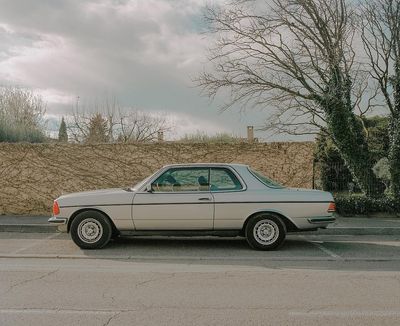 a car parked in a parking lot next to a wall