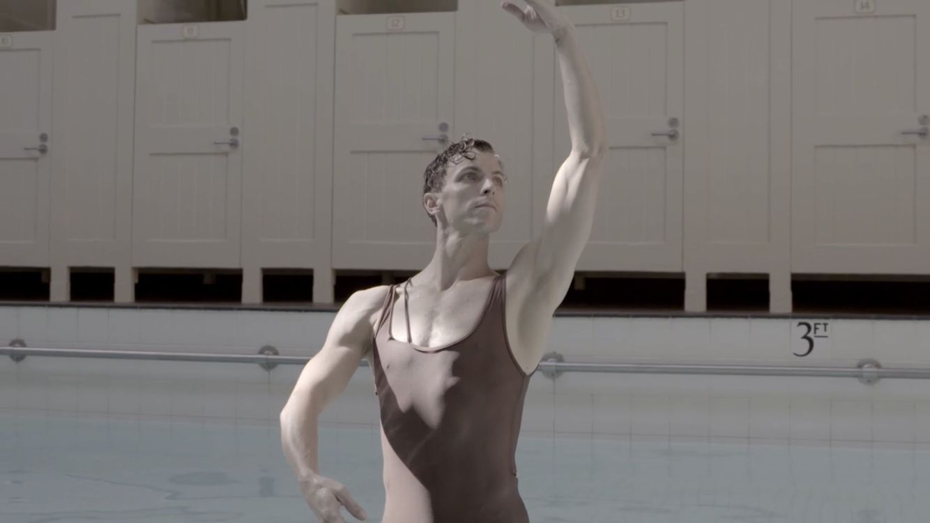 a man standing in a swimming pool holding a white frisbee