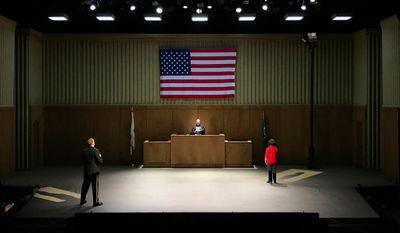 two people standing on a stage in front of an american flag