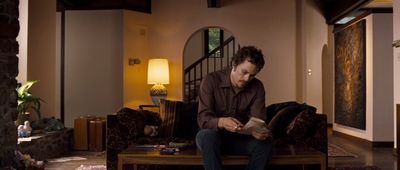 a man sitting on a couch reading a book