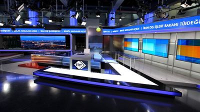 a television studio with several monitors on the wall