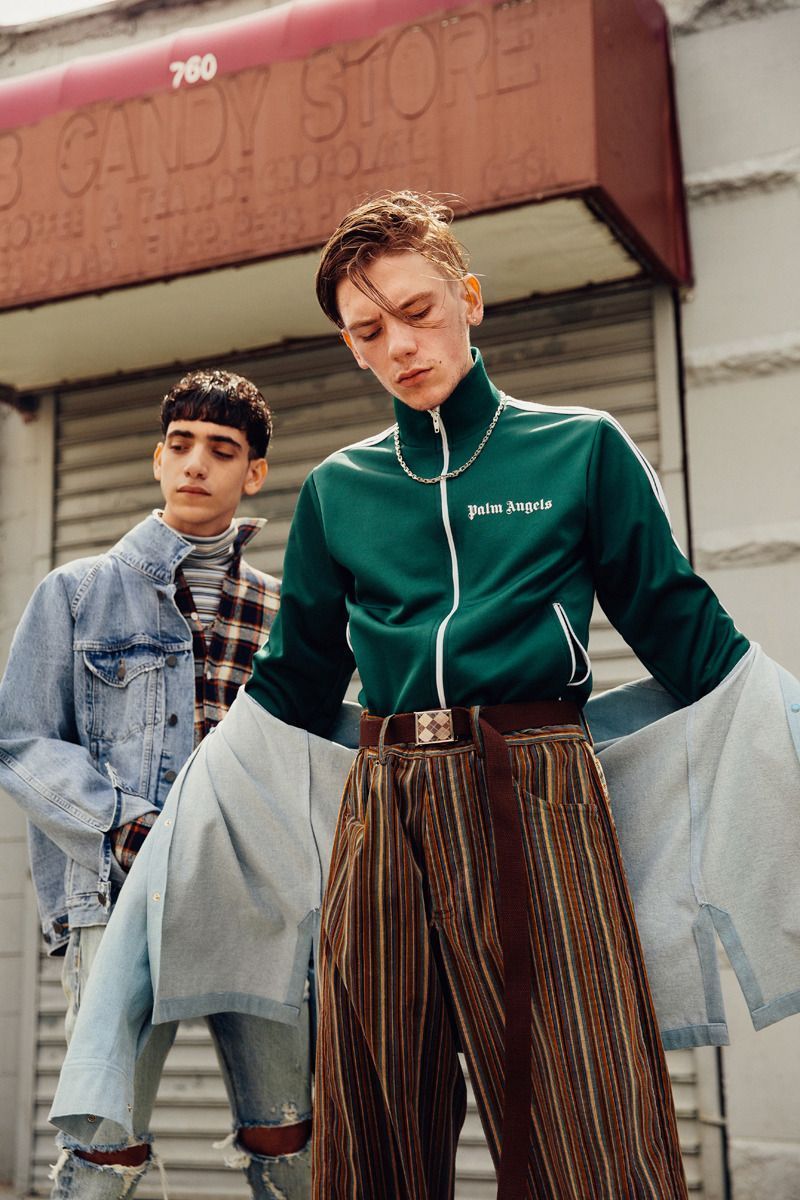 two young men standing outside of a building