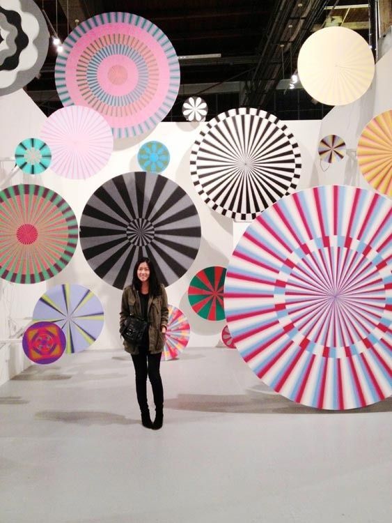 a woman standing in front of a display of umbrellas