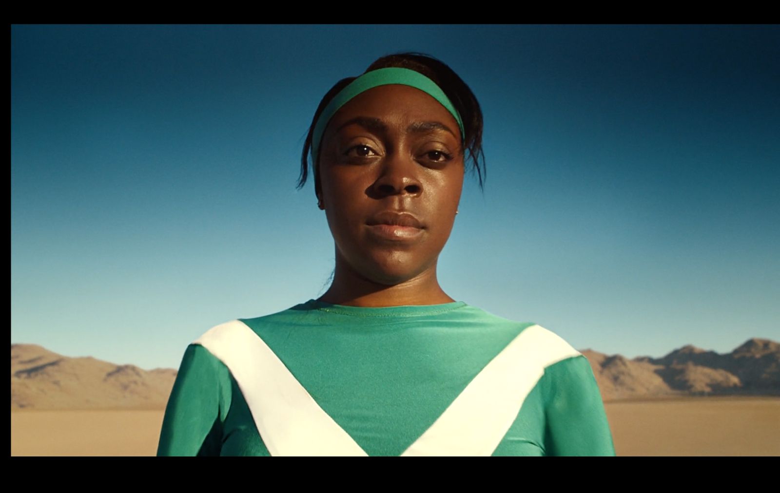 a woman in a green and white shirt and headband