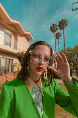 a woman wearing glasses and a green jacket