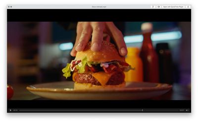 a person is holding a hamburger on a plate