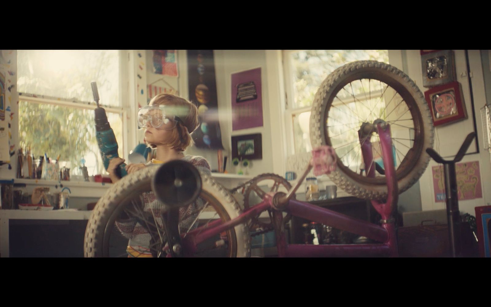 a young boy wearing goggles and a helmet standing next to a bicycle