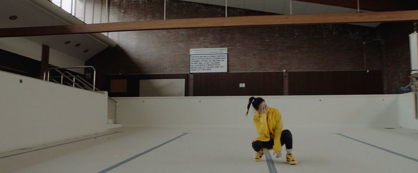 a woman in a yellow jacket standing in a room