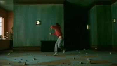 a man standing in a room with broken glass on the floor