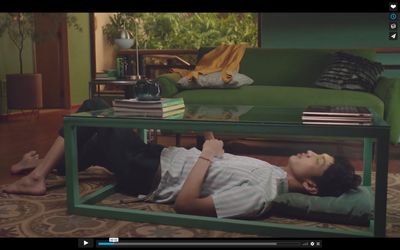 a man laying on the ground in front of a coffee table