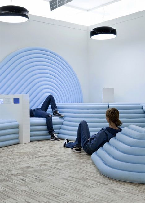 a couple of people sitting on top of blue couches